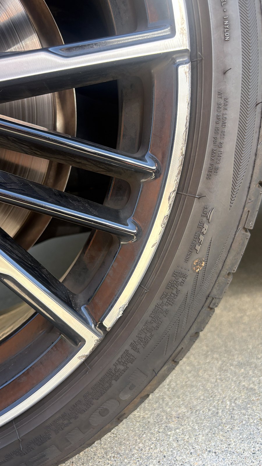 Curb rash on the machined lip of a BMW alloy wheel, before refinishing, North County San Diego