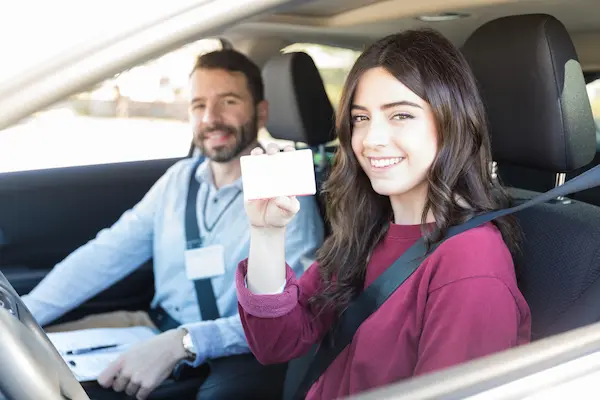 Teen student with permit card in the car with instructor