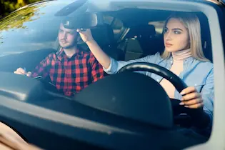 Driving instructor and student in a modern car