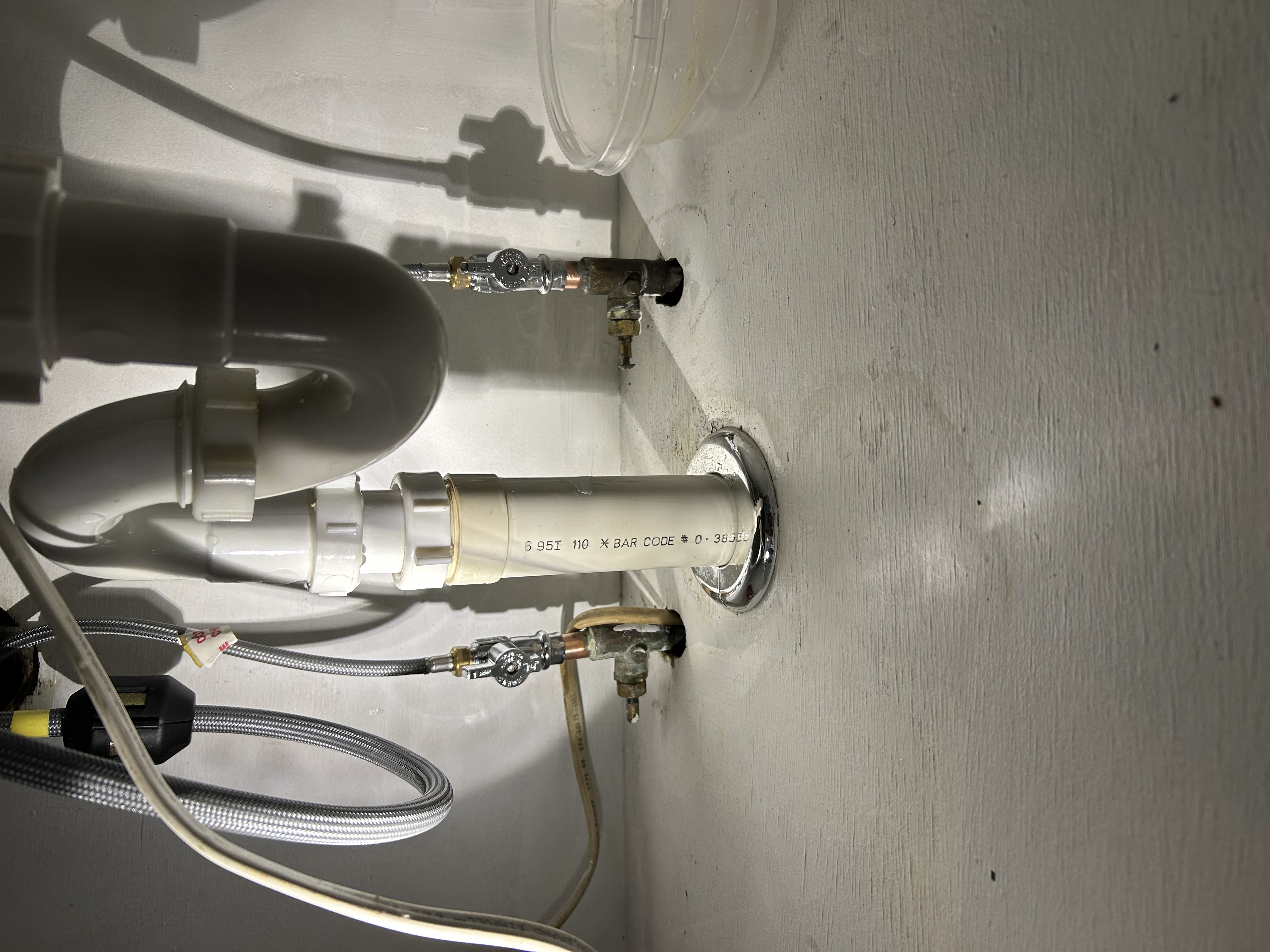 Under-sink PVC drain pipe with P-trap, shut-off valves, and braided steel supply lines