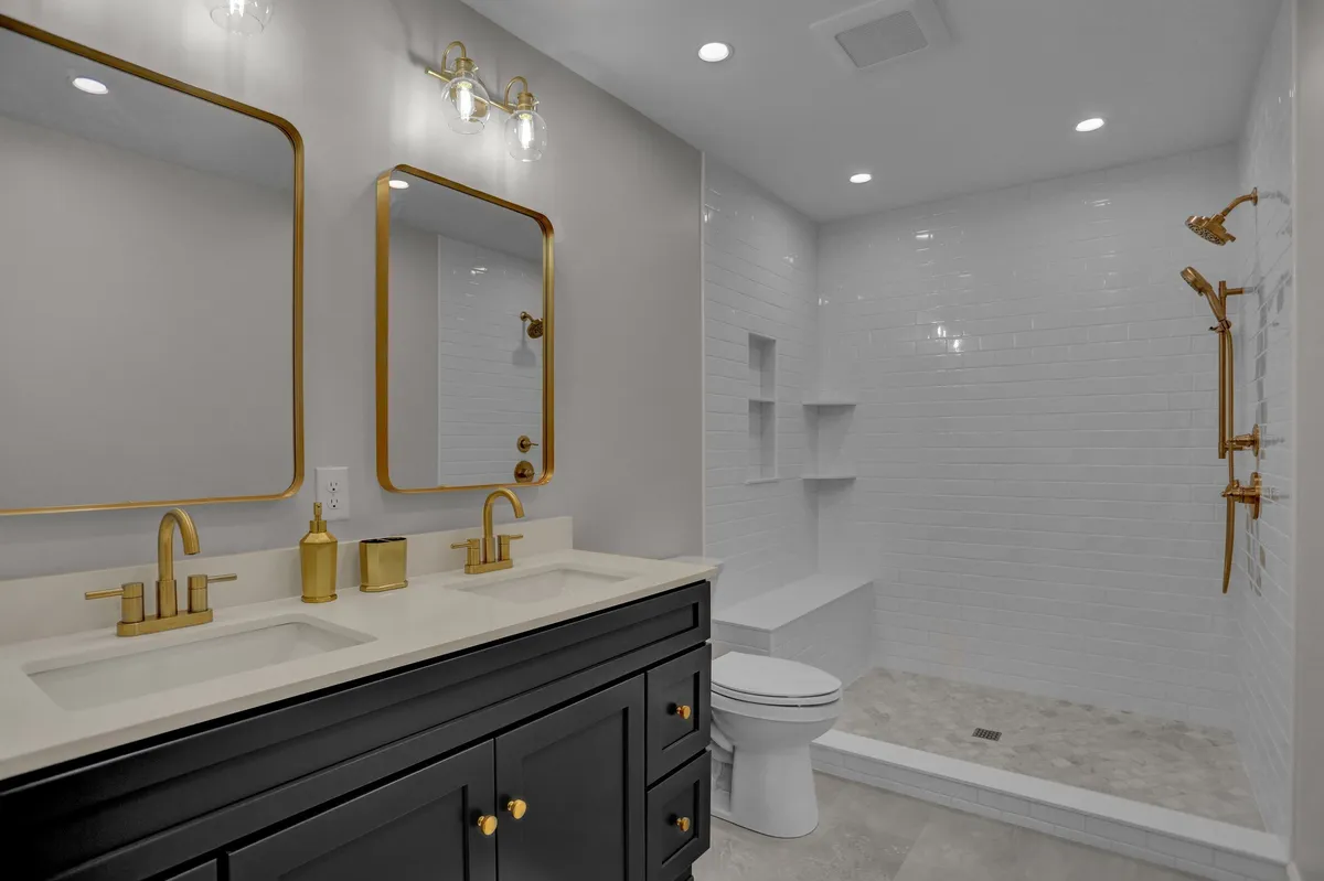 A renovated bathroom featuring a black double vanity with undermount sinks in Reading, PA by JB Plumbing HVAC & Construction