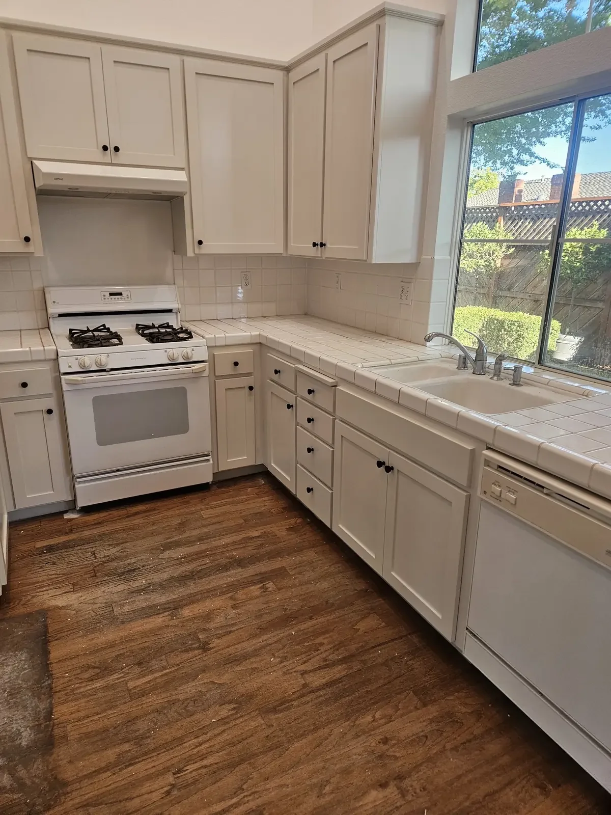 White shaker kitchen cabinets beside a sunny window