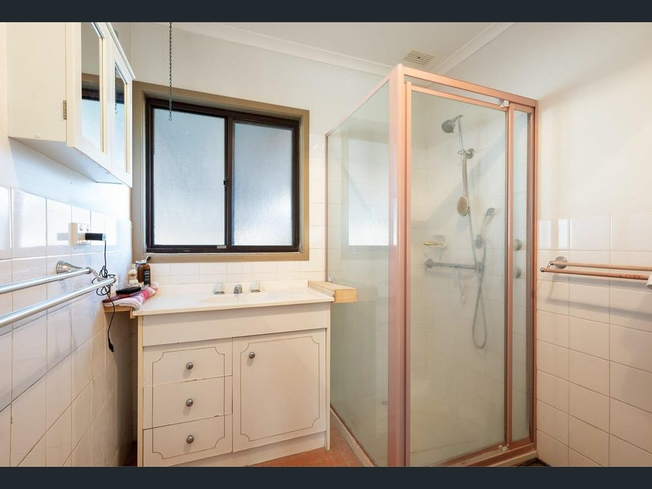 The bathroom before: old vanity and shower screen