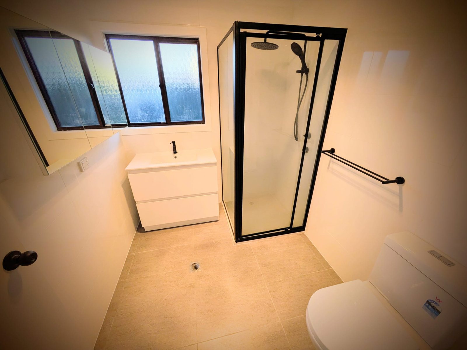 The bathroom after: new tiles, vanity and black-framed shower