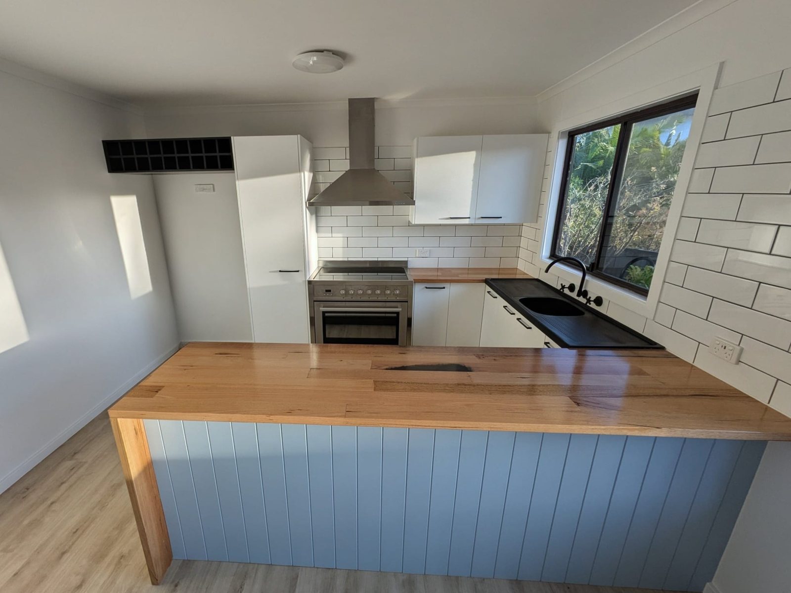 The kitchen after: timber bench, subway tiles, new appliances