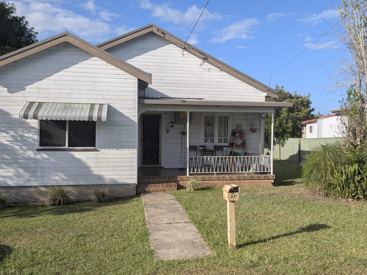 The house before: weathered weatherboard, overgrown yard