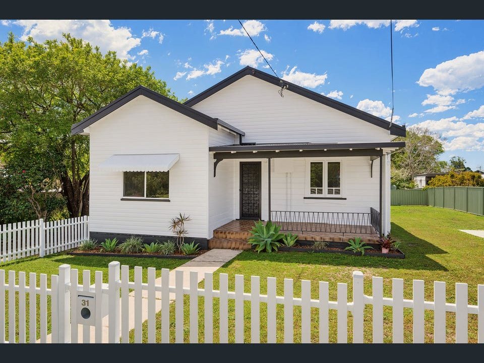 The same house after: repainted, new fence, landscaped