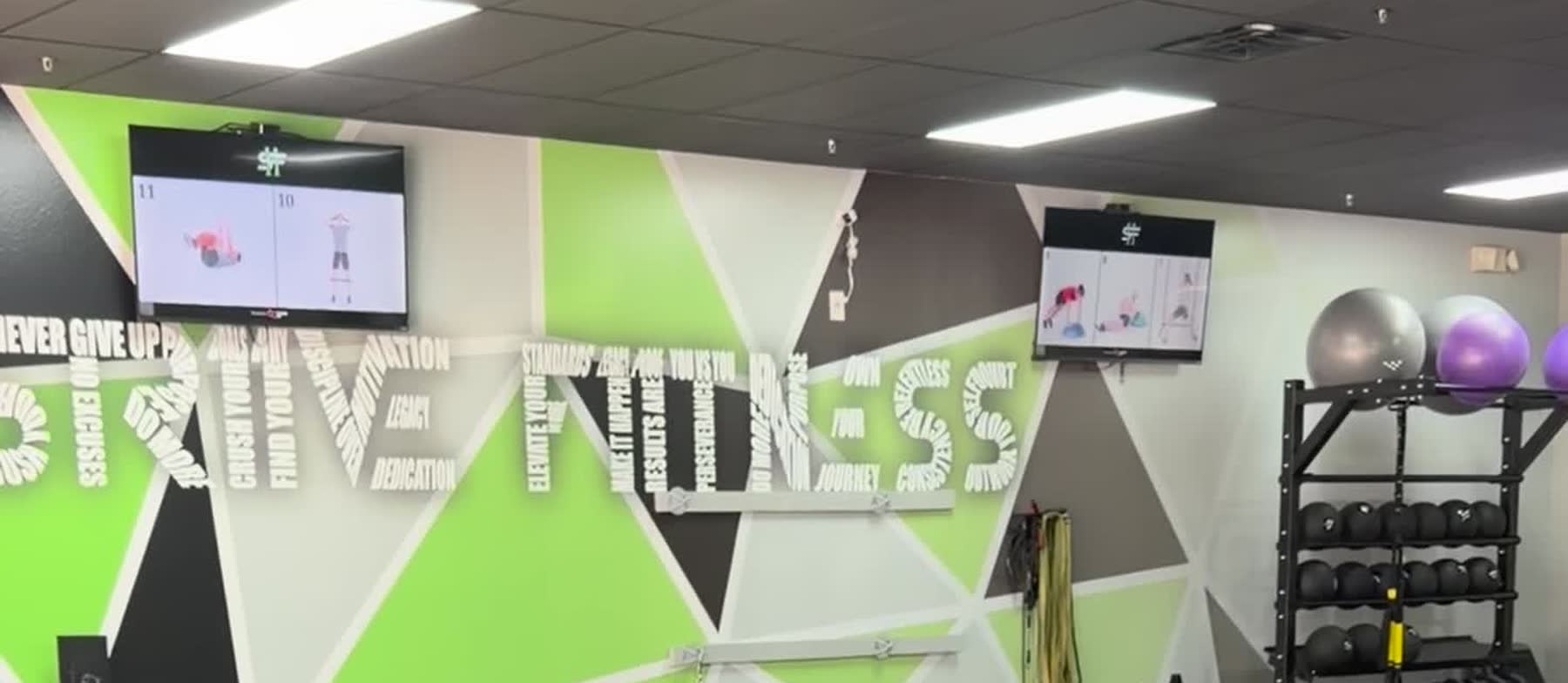 Wall screens showing numbered circuit stations above the Strive 11 word wall.