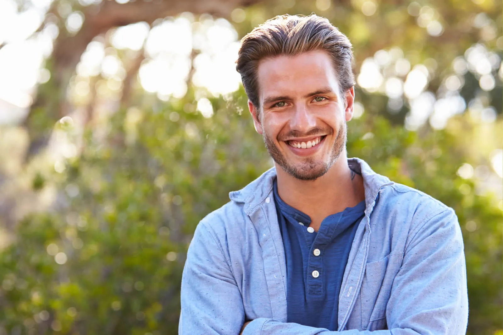 Smiling man in a blue shirt outdoors