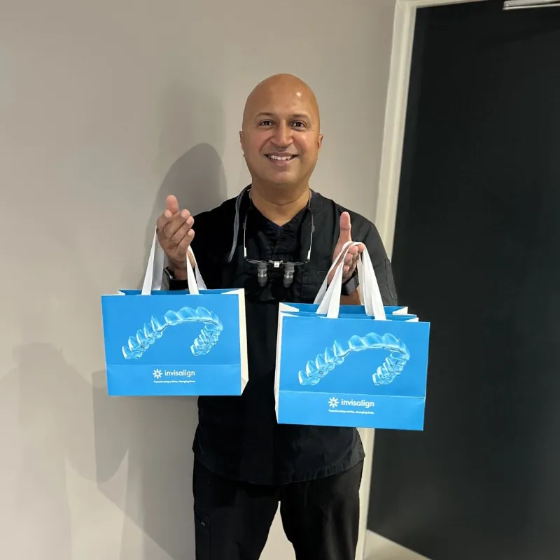 Dr Dave Basrai holding two clear aligner gift bags