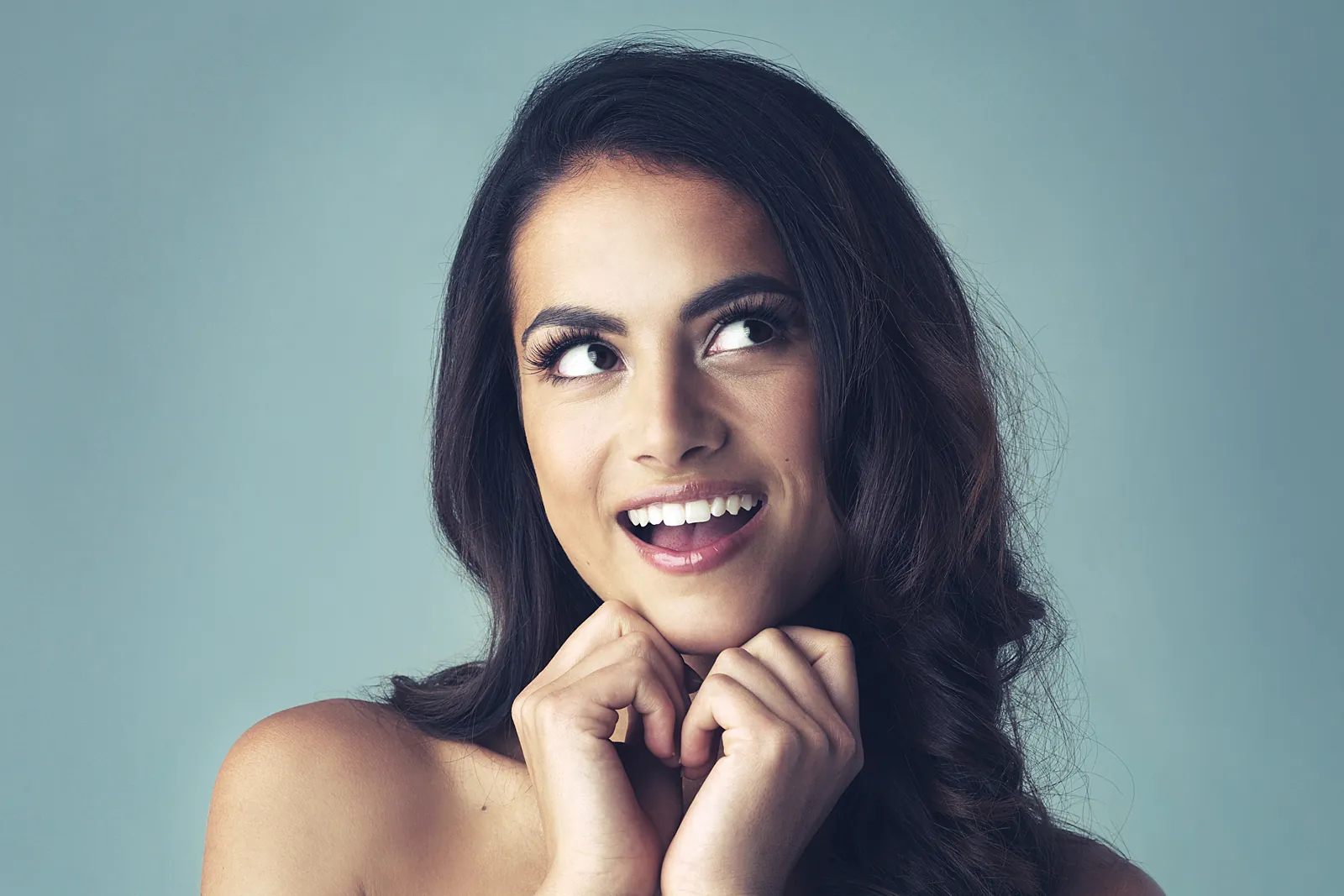 Dark-haired woman smiling and looking upwards
