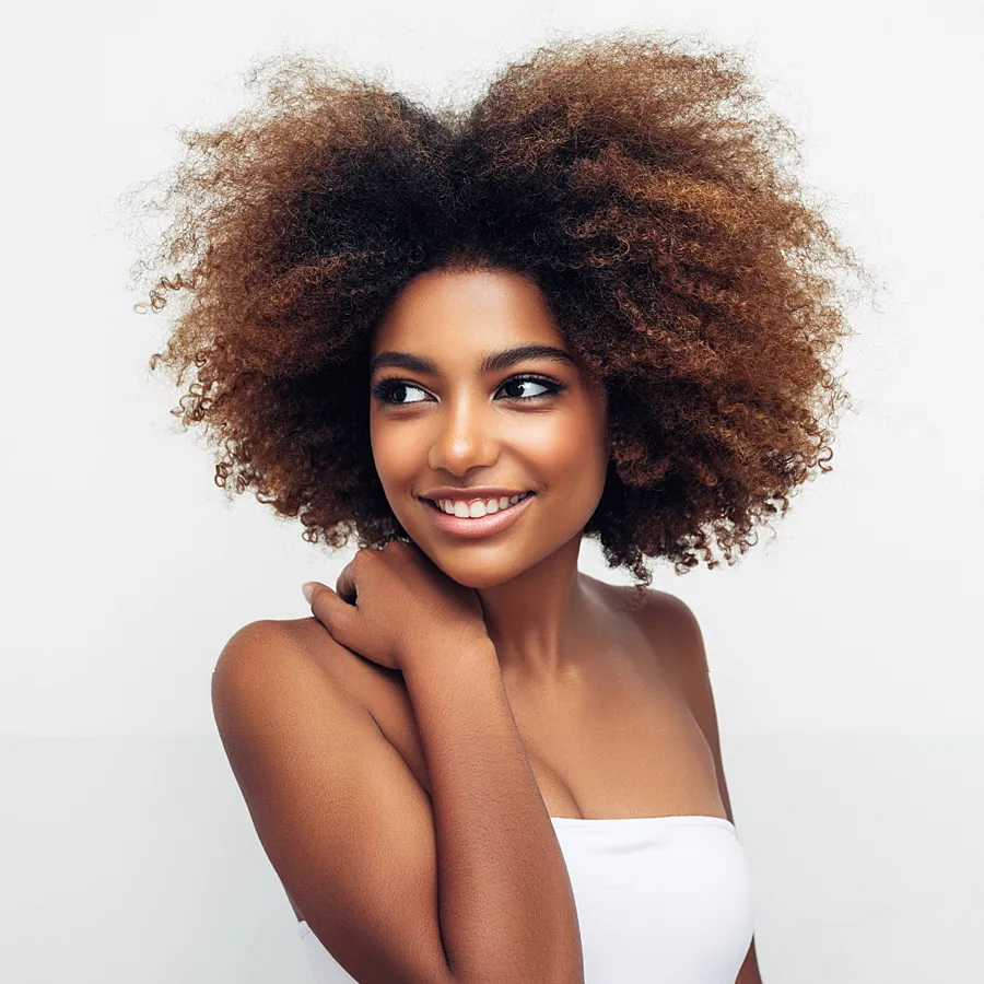 Woman with voluminous natural hair smiling warmly