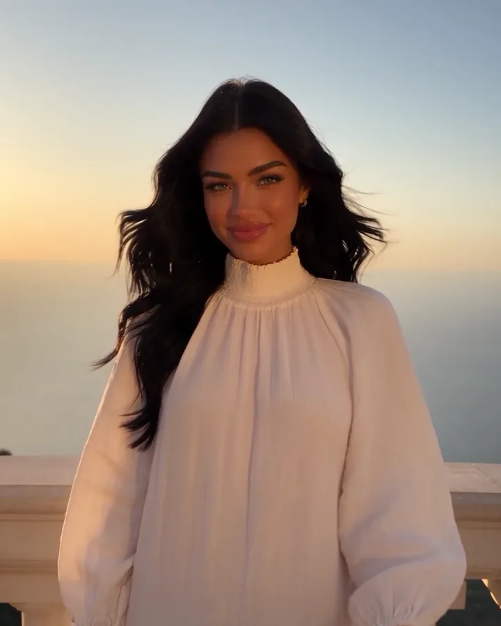 Sienna on a terrace by the sea (AI-generated image of Sienna, our AI brand ambassador)