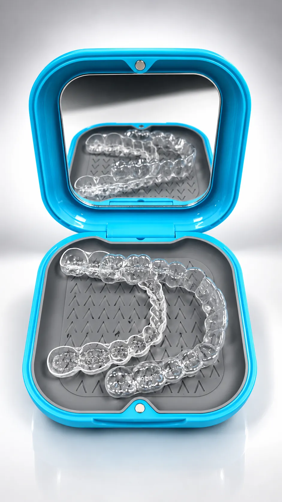 Spark clear aligners in their open blue case with a mirror in the lid