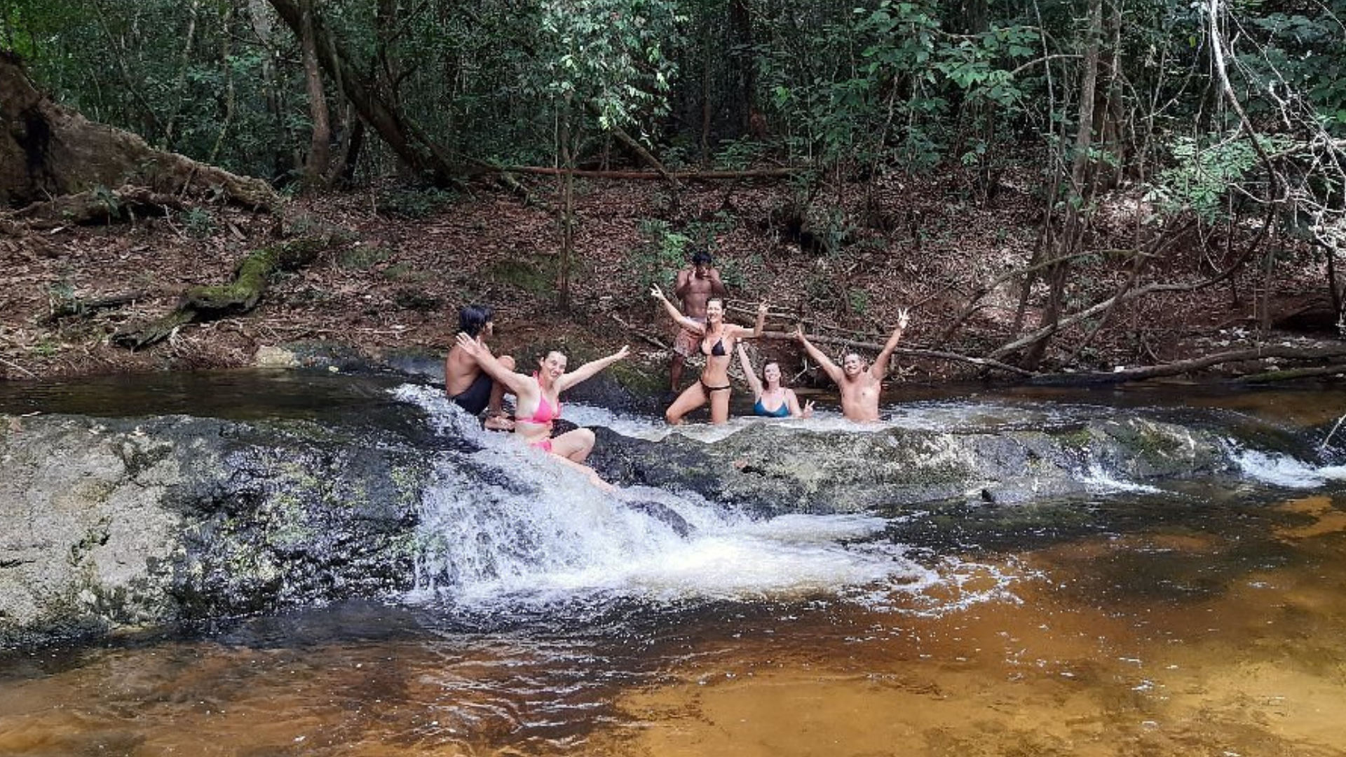 Traveler swimming in the crystal-clear Comapi Rapids deep in the Amazon rainforest.