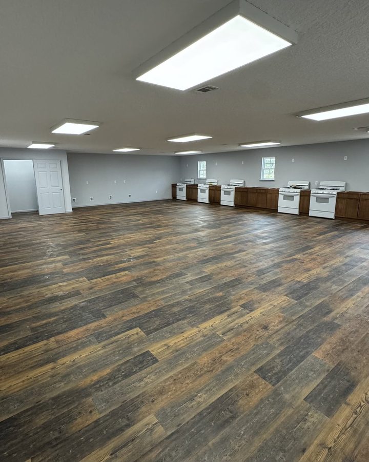 After: large open room with new wood-look plank flooring