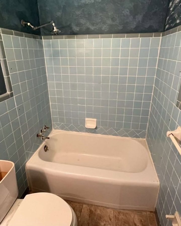 Before: bathtub with blue wall tile in a hall bathroom alcove