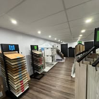 Flooring sample displays and wood-look plank floor in the Woodard Restoration showroom