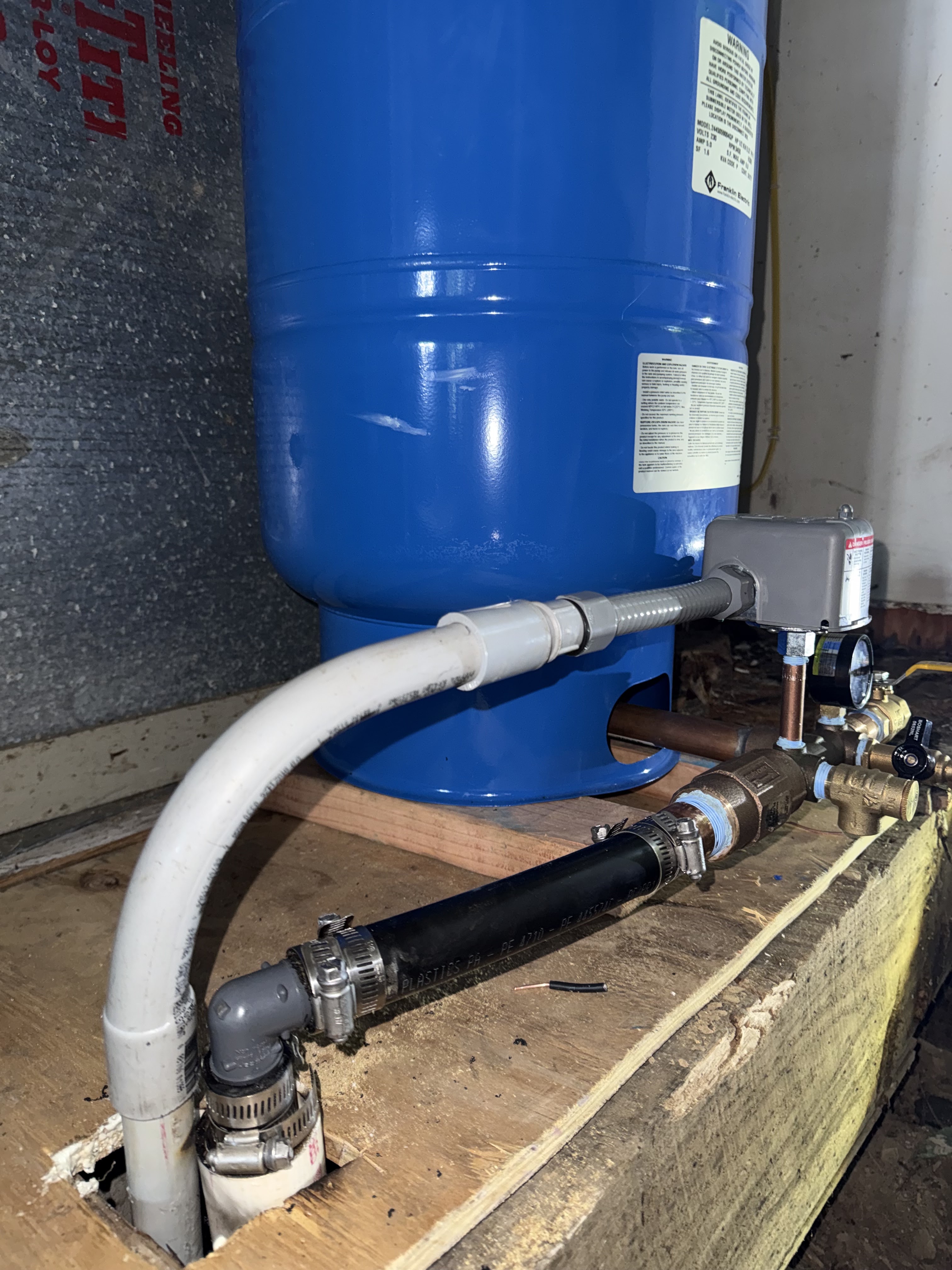 Well pump and pressure tank equipment installed in a basement