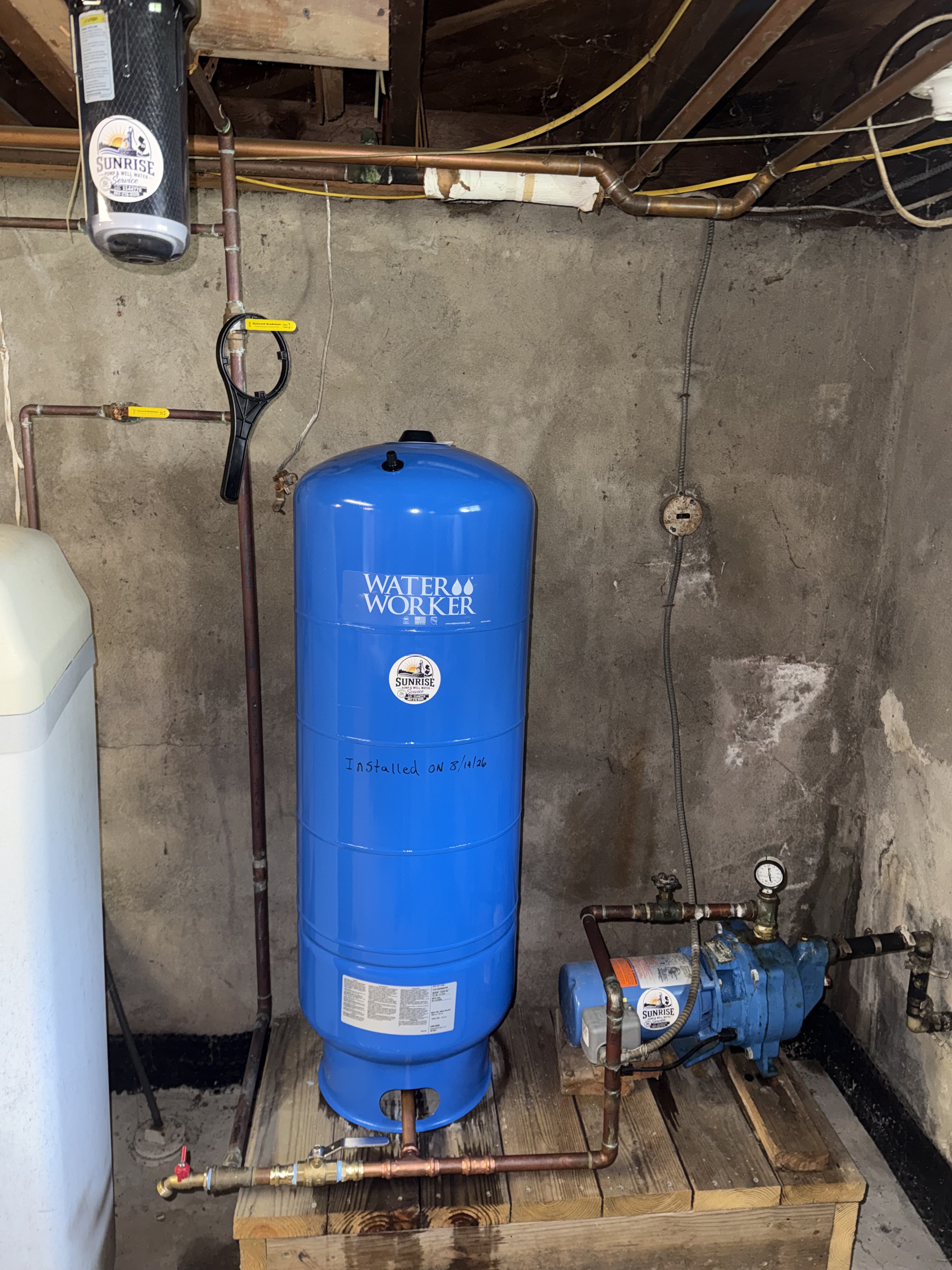 Austen Yanish working on a well pump and pressure tank on a job
